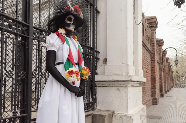 Eine Frau, die als traditionelle mexikanische weibliche Skelettfigur La Calavera Catrina verkleidet ist und den Tod symbolisiert