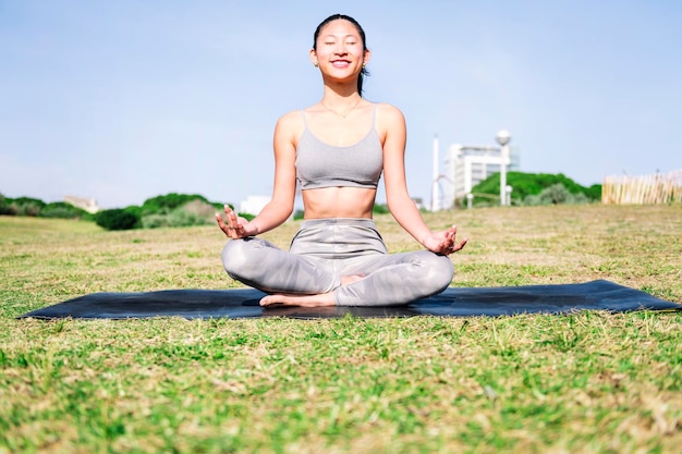 Eine Frau, die auf einer Yoga-Matte sitzt und meditiert