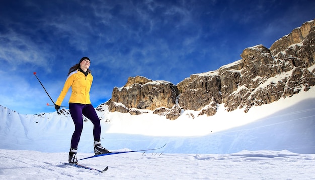 Eine Frau, die auf Schnee Ski fährt, in voller Länge