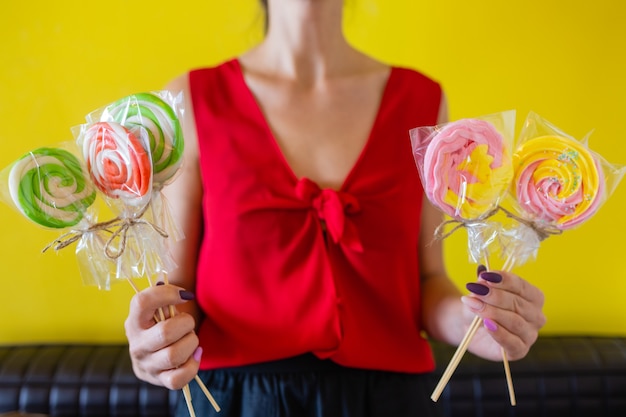 Eine Frau, die eine bunte Süßigkeit in der Hand hält.