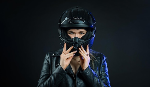 Eine Frau, die einen Motorradhelm auf dunklem Hintergrund trägt Das Konzept des Raums