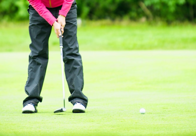 eine Frau, die Golf spielt, ist dabei, einen Ball zu schlagen