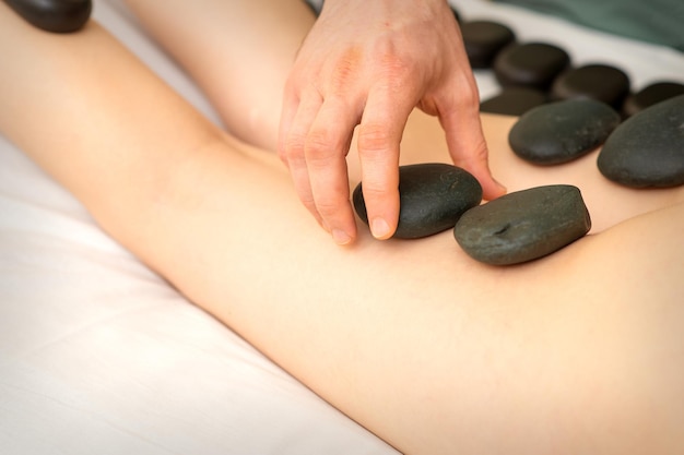 Eine Frau, die in einem Schönheitssalon eine Spa-Hot-Stone-Therapie für die Beine bekommt.