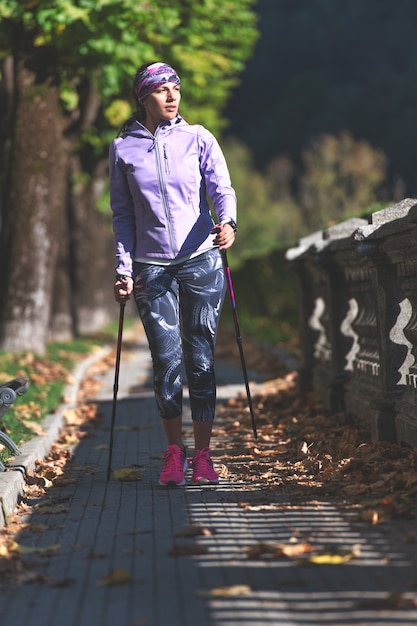 Eine Frau entspannt sich nach einem intensiven Arbeitstag beim Nordic Walking