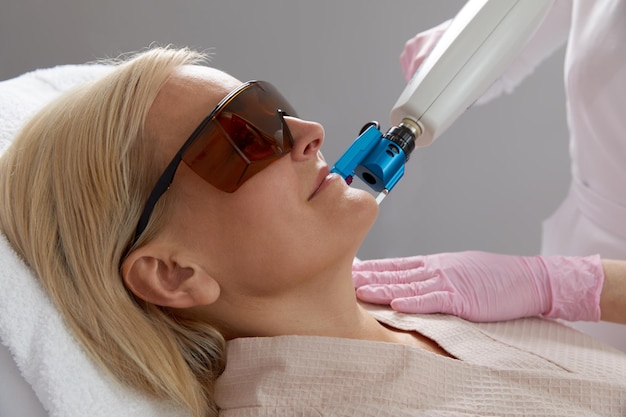 Eine Frau erhält eine Laserbehandlung in einer modernen Kosmetikklinik