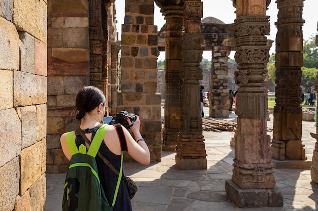 Eine Frau fotografiert ein altes Gebäude in Indien