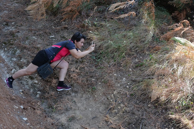 Foto eine frau fotografiert ein tier mit einem handy im wald