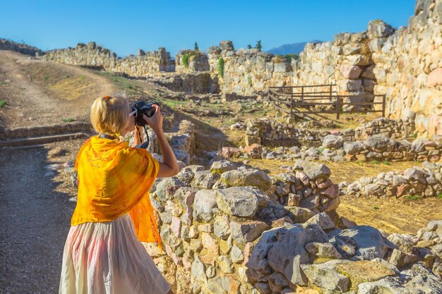 Foto eine frau fotografiert mit einer kamera, während sie an einer alten ruine steht