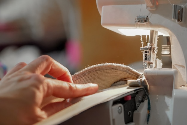 Eine Frau führt Arbeiten am Overlock durch