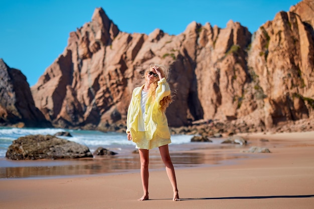 Foto eine frau geht am ufer entlang mit einem felsigen blick auf das meer