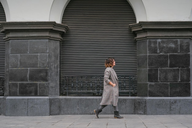 Eine Frau geht eine Straße mit antiker Architektur in der Mitte des Bildes entlang