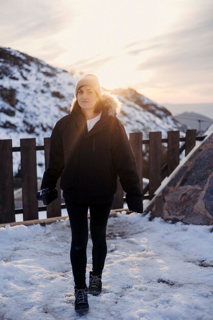 Foto eine frau geht im schnee vor einem berg