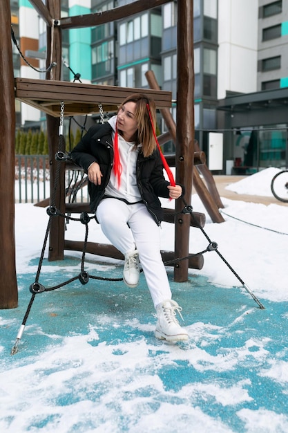 Eine Frau geht im Winter auf der Straße in einem Komplex für Kinder