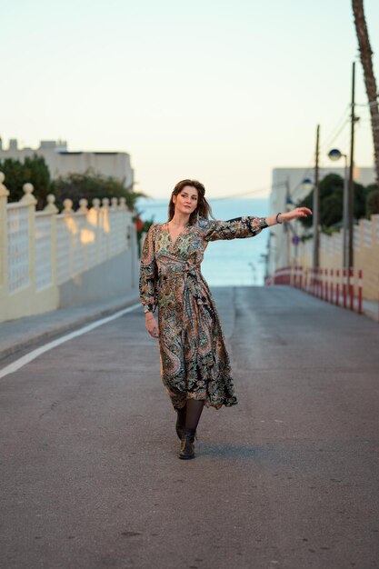 Foto eine frau geht in einem kleid die straße entlang