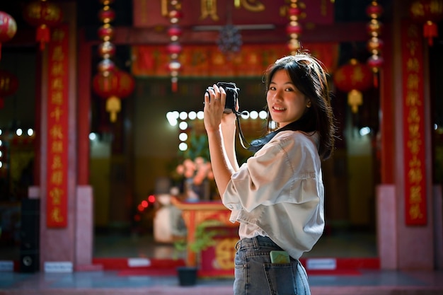 Eine Frau genießt ihre Alleinreise nach Asien und fotografiert einen wunderschönen chinesischen Tempel