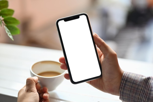 Eine Frau hält ein Handy mit einem weißen, leeren Bildschirm für Ihre Werbetextnachricht