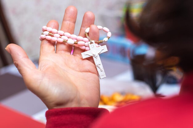 Eine Frau hält ein kleines Kreuz mit einer Halskette in der Hand