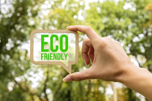 Eine frau hält ein schild, in dem die aufschrift eco friendly ecology concept steht