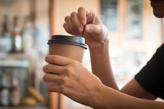 Eine Frau hält eine Kaffeetasse in der Coffee-Shop am Mittag.