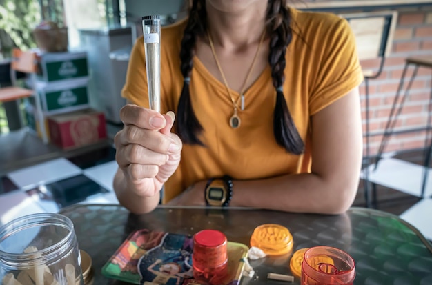 Foto eine frau hält eine zigarette mit cannabis in einem plastikbehälter in der hand und legalisiert den verkauf