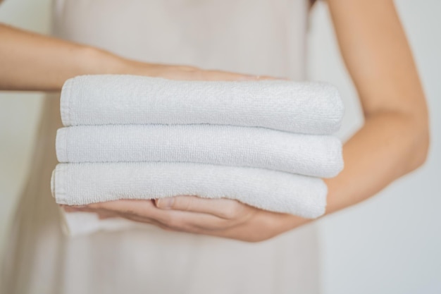 Eine Frau hält einen Stapel weißer Handtücher Konzept des Service in Hotels Wäscherei Spa