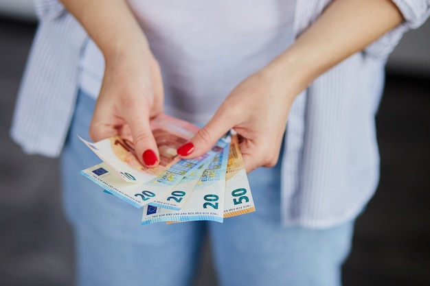 Foto eine frau hält euro-geld in ihren händen.