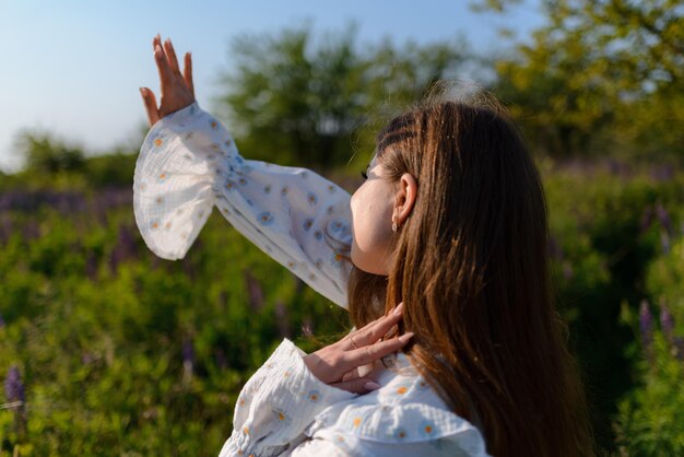 Eine Frau hebt ihre Hand zum Himmel und genießt die Sonne