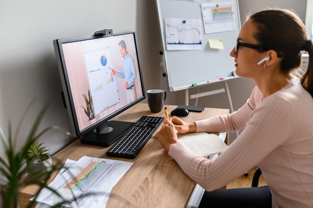 Eine Frau im Büro schaut sich Online-Kurse an.