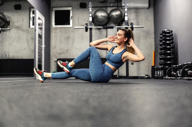 Eine Frau im Fitnessstudio, die Situps macht