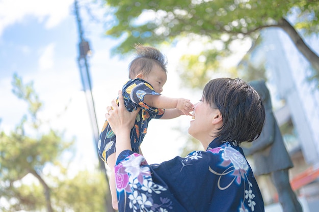 Eine Frau im Kimono hält ein Baby im Arm.