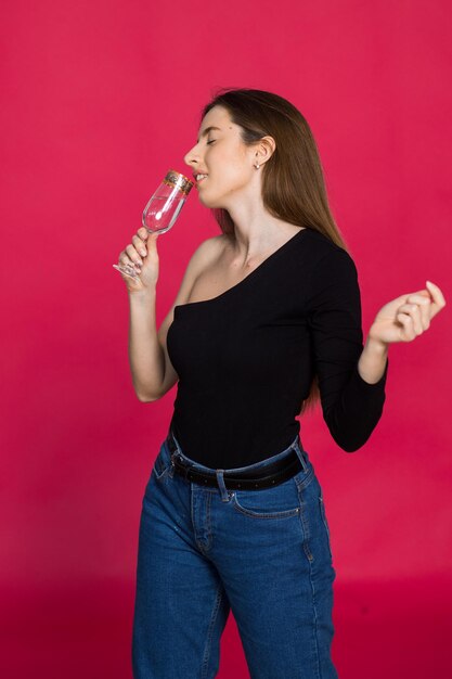 Eine Frau im Studio mit einem Glas Champagner wartet auf das Weihnachtsfest 2023