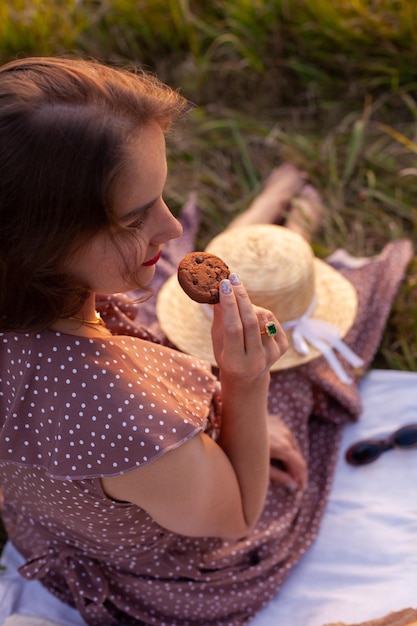 Eine Frau in braunem Kleid sitzt auf einem Picknick in einem Park mit Panoramablick