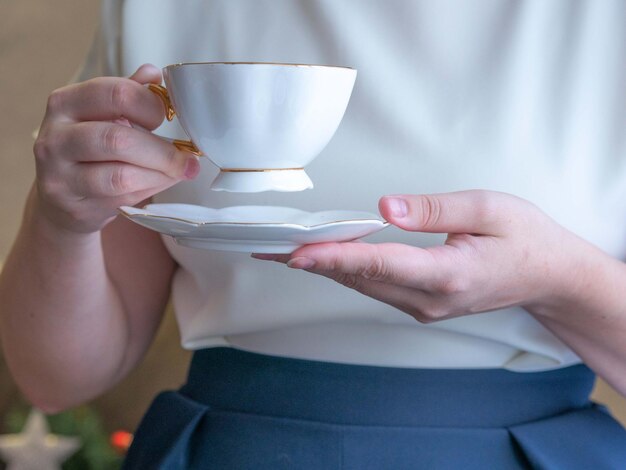 Eine Frau in Bürokleidung hält eine weiße Tasse Tee Pausentee im Büro Lichtrahmen