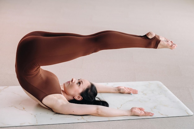 Foto eine frau in einem braunen anzug macht yoga in einem fitnessraum gesunder lebensstil fitnesstraining selfcare