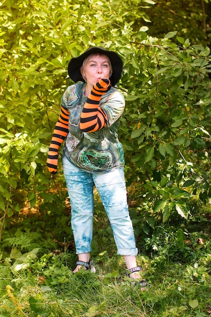 Eine Frau in einem Hexenhut für Halloween Ein fröhlicher Zwerg in der Natur