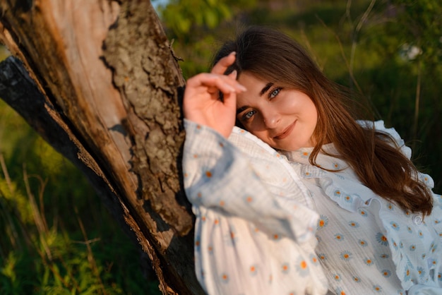 Foto eine frau in einem retro-kleid steht an einem baum und schaut in die kamera