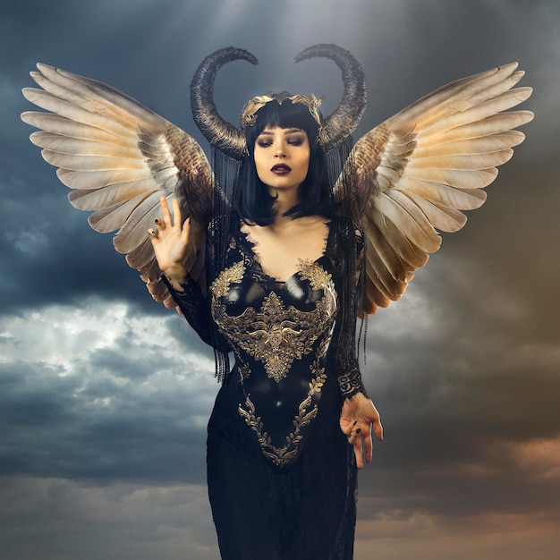 eine Frau in einem schwarzen Kleid mit Hörnern und Teufelhörnern
