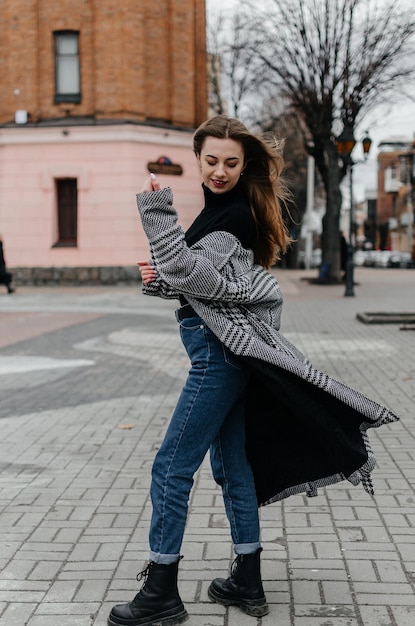 Eine Frau in einem schwarzen Pullover und Jeans auf einer Straße