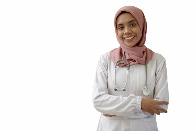 Eine Frau in einem weißen Gewand mit einem Stethoskop auf dem Kopf steht vor einem weißen Hintergrund.