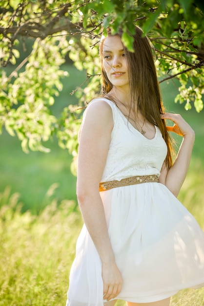 eine Frau in einem weißen Kleid mit einem braunen Gürtel