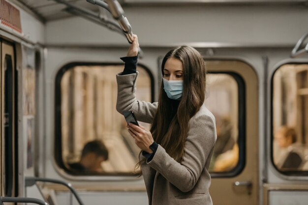 Eine Frau in einer medizinischen Gesichtsmaske an der U-Bahnstation