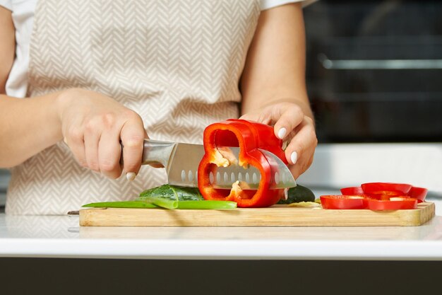 Eine Frau in einer modernen Küche schneidet Gemüse mit einem Messer Kochen etwas Gesundes und Leckeres