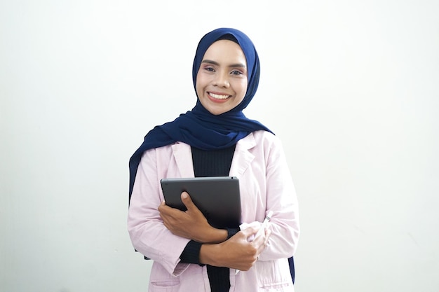 Eine Frau in einer rosa Jacke hält ein Tablet in ihren Händen.