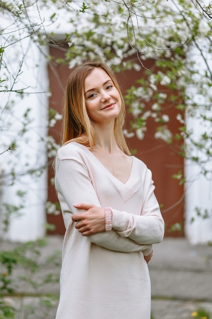 Eine Frau in einer weißen Bluse steht in einer Kirschblüte