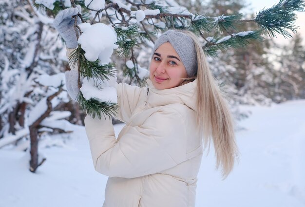 Eine Frau in einer weißen Jacke und Hut steht im Schnee