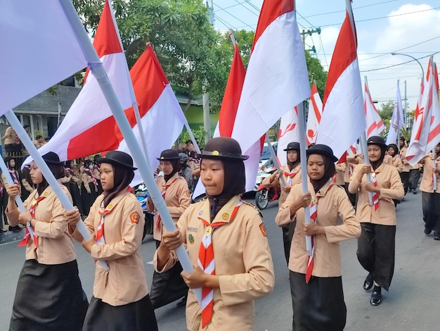 eine Frau in Uniform trägt während einer Parade Fahnen.