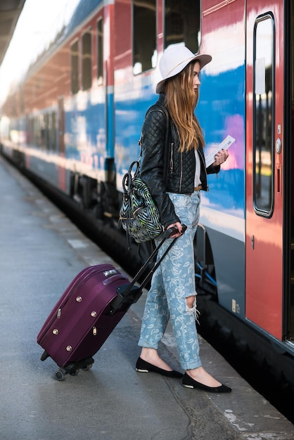 Eine Frau in voller Länge steht auf dem Bahnhofssteig