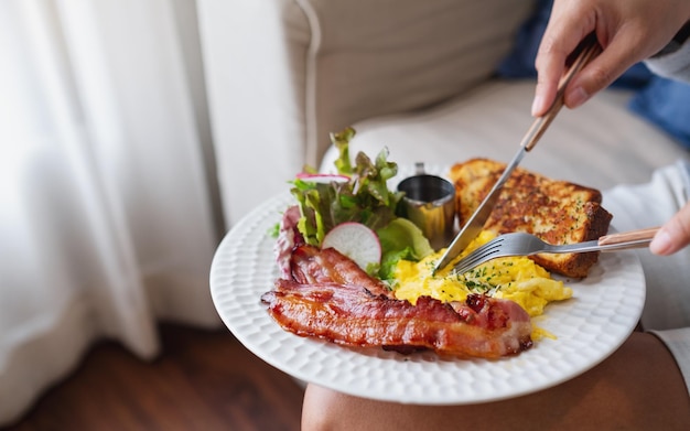Eine Frau isst zu Hause ein amerikanisches Frühstück