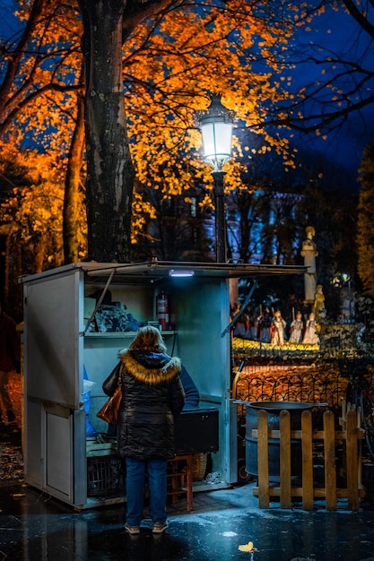 Eine Frau kauft Kastanien an einem Stall