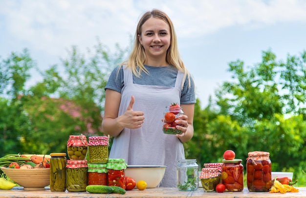 Eine Frau konserviert Gemüse in Gläsern Selektiver Fokus